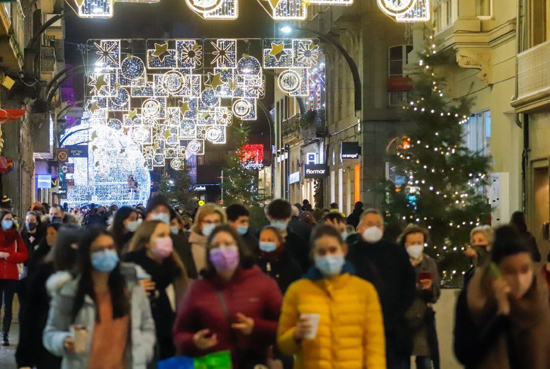 Varias personas pasean por la Calle de Príncipe, en Vigo (España, durante la pandemia de coronavirus.