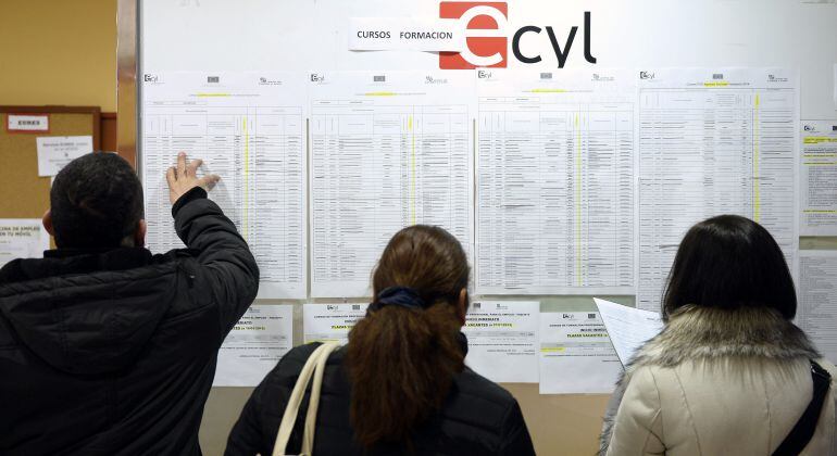 Tres personas consultan la información expuesta en una oficina de empleo del ECyL de Valladolid