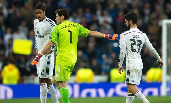 MADRID, SPAIN - MARCH 10: goalkeeper Iker Casillas (2ndL) of Real Madrid CF holds his teammate Francisco Roman Alarcon alias Isco (R) in order to greets the audience close to Raphael Varane (L) after loosing the UEFA Champions League round of 16 second le