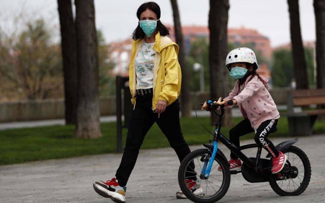 Una madre pasea con su hija el primer día de desconfinamiento infantil