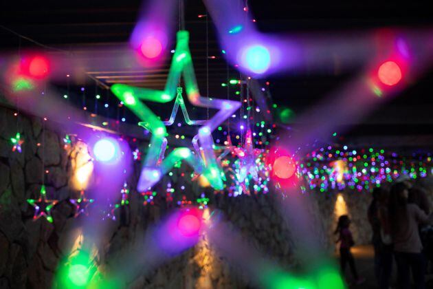 Una familia bajo las luces durante el Festival anual de luces en los Jardines Botánicos Waler Sisulu en la navidad en Johannesburgo, Sudáfrica.