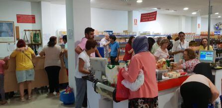 Numerosas personas comprando en el economato Resurgir (Huelva)