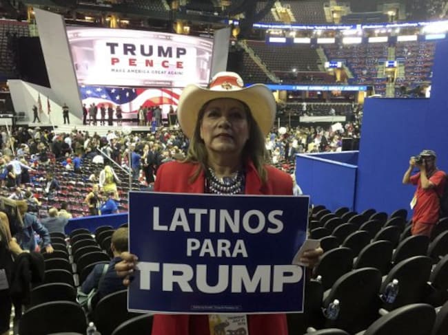 Una mujer sostiene un cartel de "Latinos para Trump"