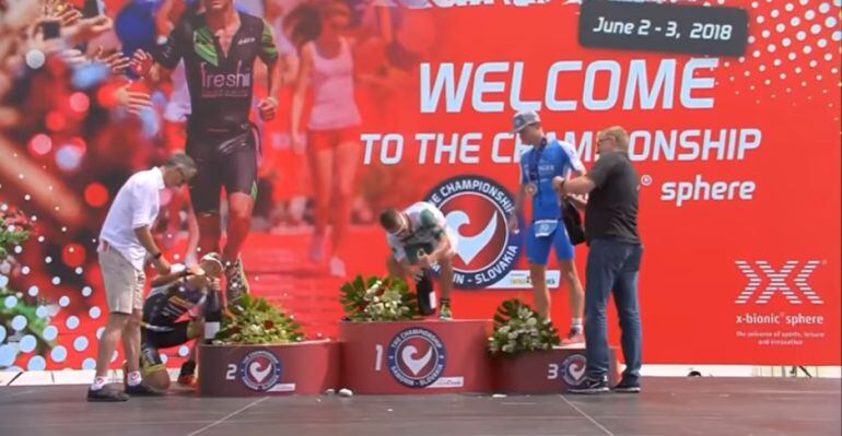 El canadiense Lionel Sanders y los alemanes Sebastian Kienle y Florian Angert intentan abrir sus botellas de champagne en el podio