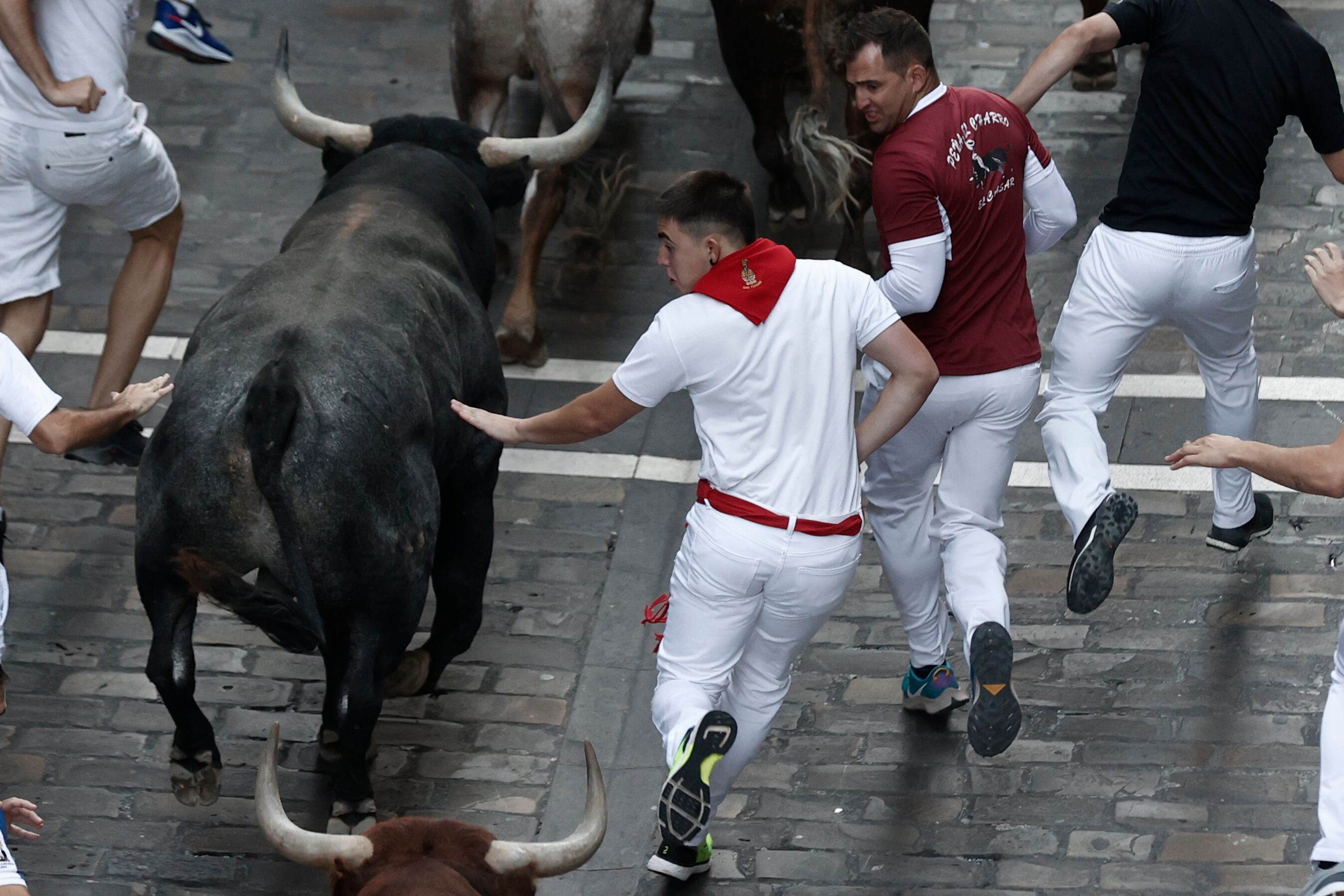 PAMPLONA, 14/07/2022.- Los mozos, durante el octavo y último encierro de los Sanfermines 2022 con toros de la ganadería de Miura en Pamplona. EFE/Jesús Diges