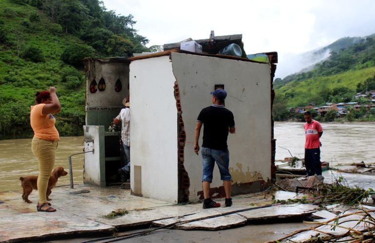 pobladores de la zona del rio Cauca, tratan de evitar las inundaciones causadas por el corrimiento de rocas en la presa.