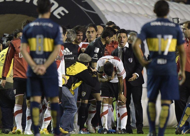 Argentina&#039;s River Plate footballers react after being pepper sprayed  by Boca Junior supporters before the start of the second half of the Copa Libertadores 2015 second leg football match at the &quot;Bombonera&quot; stadium in Buenos Aires, Argentina, on May 14, 2