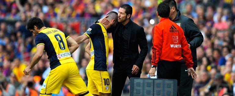 El turco recibe un gesto cariñoso de Simeone durante un encuentro del Atlético de Madrid.