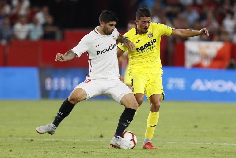 El centrocampista argentino del Sevilla, Ever Banega (i), disputa el balón ante el jugador del Villarreal, Pablo Fornals, durante el encuentro correspondiente a la segunda jornada de primera división que disputan esta noche en el estadio Sánchez Pizjuán, en Sevilla.