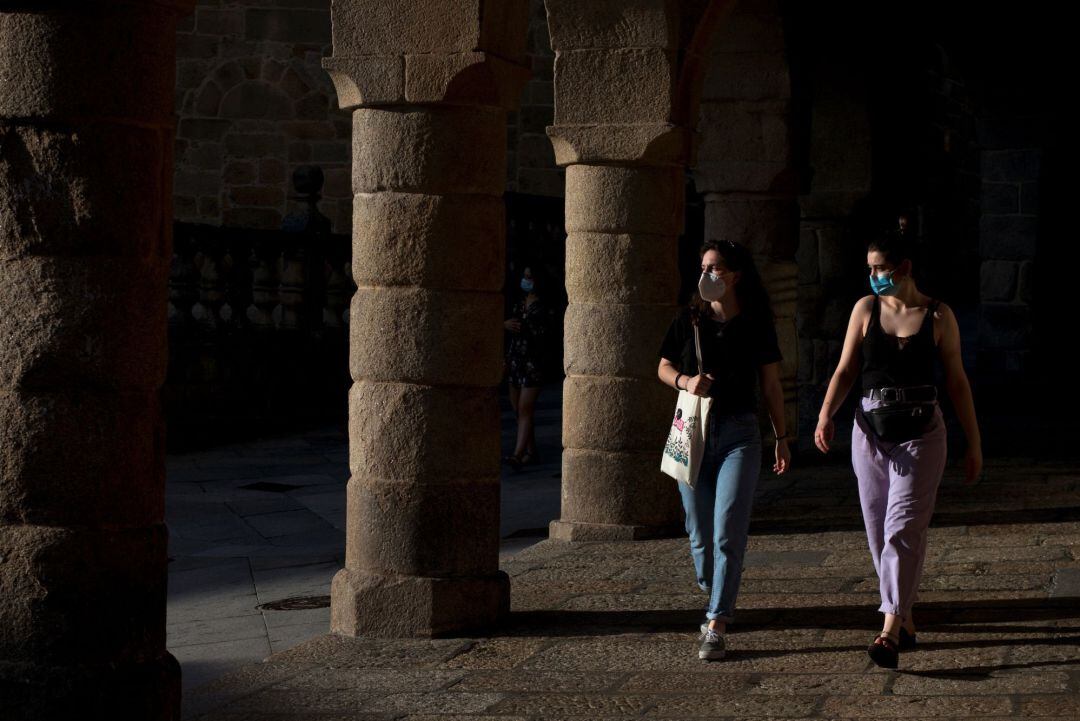 Dos jóvenes con mascarillas por el casco antiguo