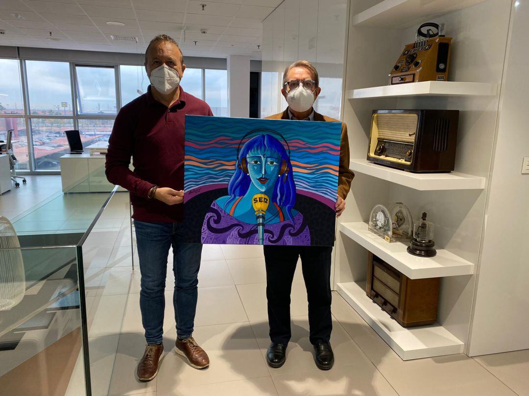 El director de Radio Castellón Cadena Ser posa junto al artista Luis Bolumar sosteniendo la obra 'Locutora en cadena'