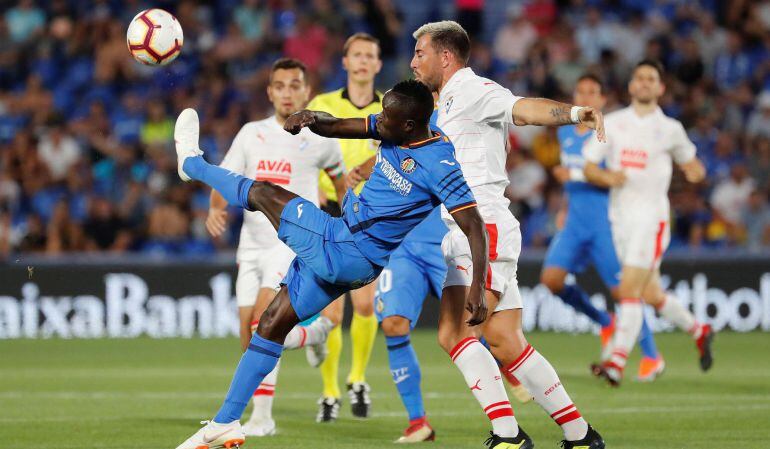 El defensa togolés del Getafe, Djene Dakoman (i), golpea el balón ante el delantero del Eibar, Sergi Enrich, durante el encuentro correspondiente a la segunda jornada de primera división que disputaron en el Coliseum Alfonso Pérez de Getafe. .