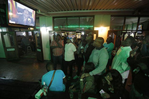 Los ciudadanos de Zimbabue viendo en la televisión el discurso de este domingo de Mugabe