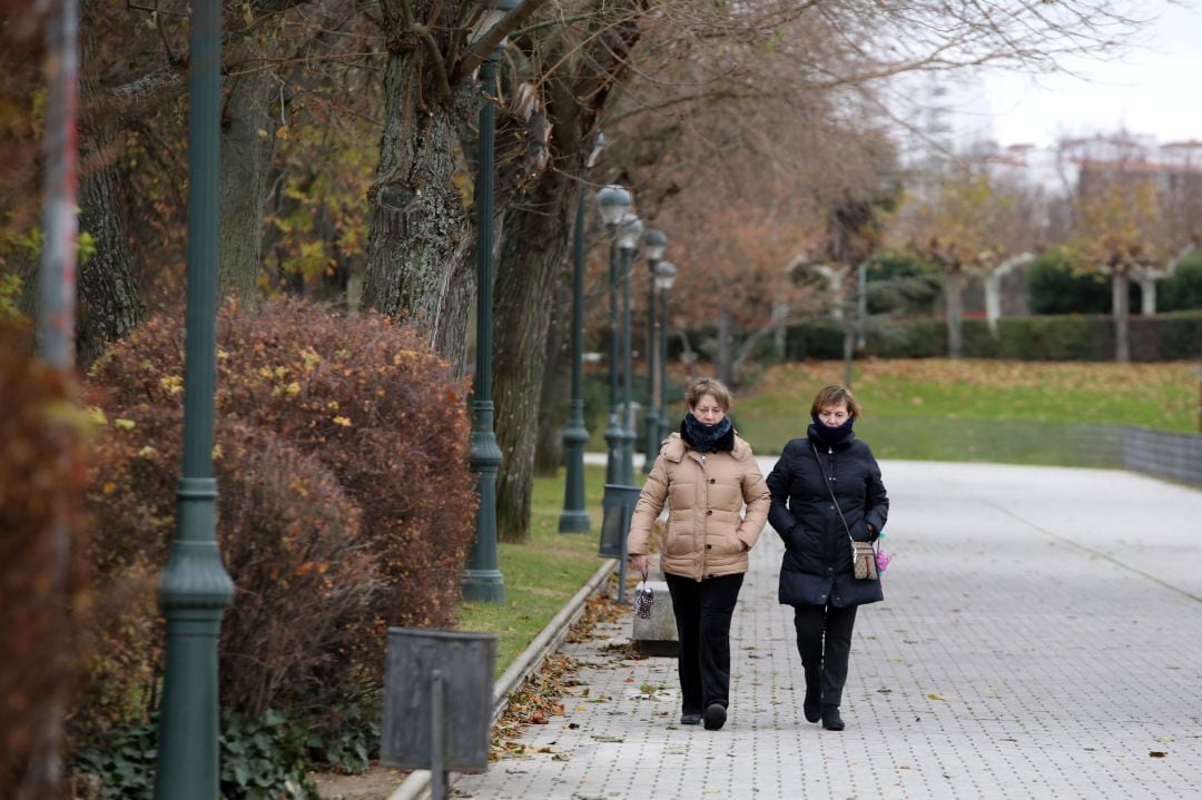 Dos mujeres se protegen del viento