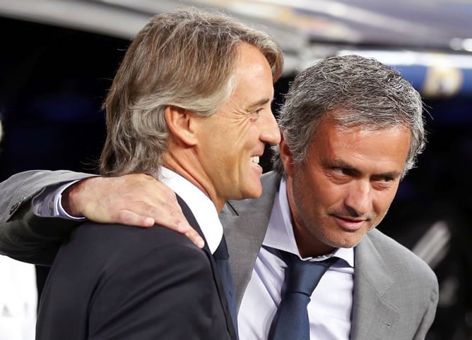 El entrenador del Real Madrid, el portugués Jose Mourinho (d), rodea con un brazo al del Manchester City, el italiano Roberto Mancini