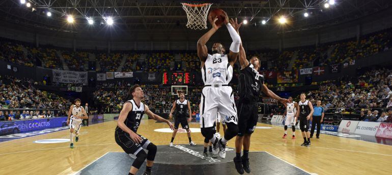 El alero estadounidense de Dolomiti Energia Trento, Dominique Sutton (c), lanza a canasta junto al base estadounidense Clevin Hannah (d), del Dominiaon Bilbao Basket, durante el partido de Eurocopa que se disputa esta tarde en Bilbao