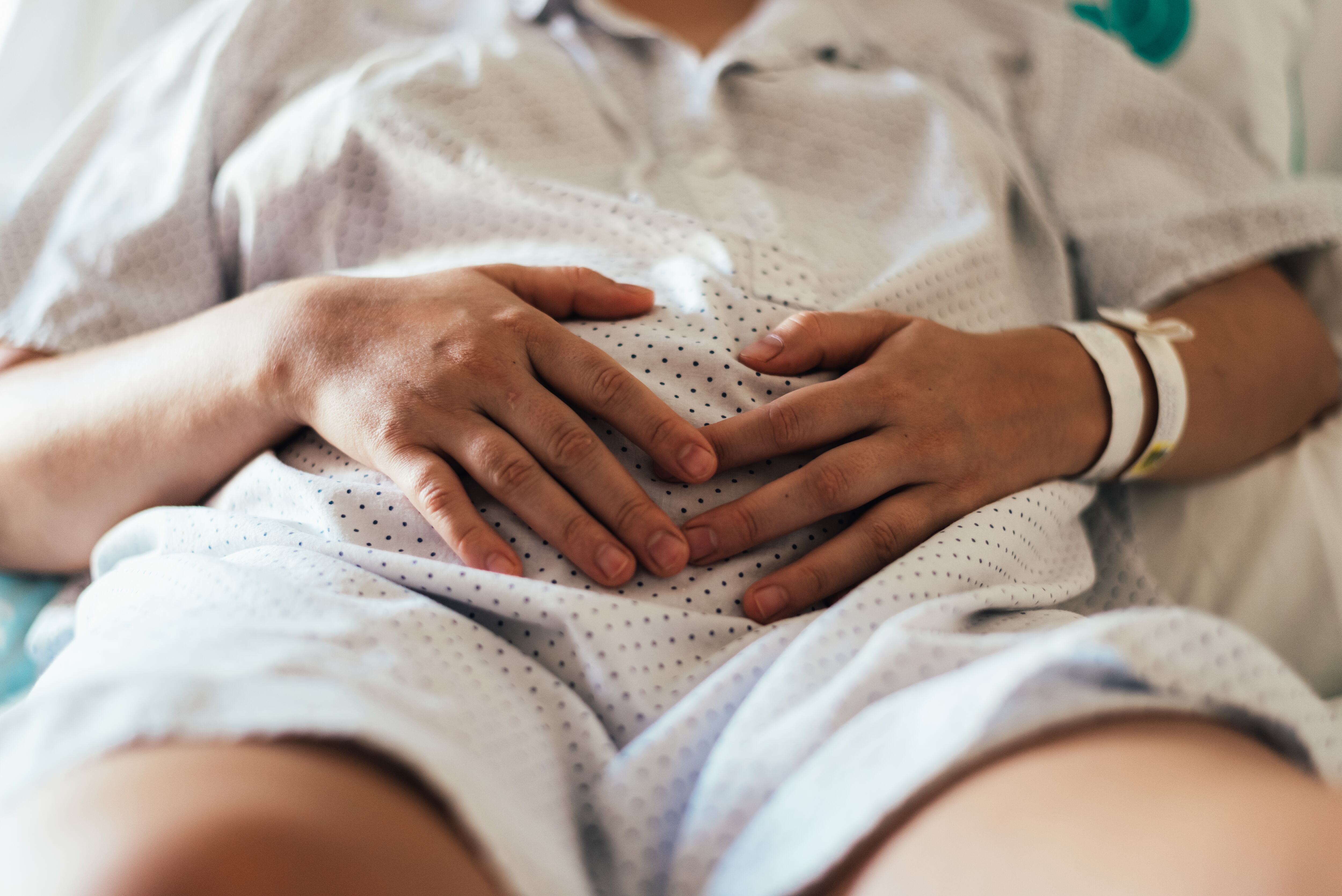 Una paciente recostada en una cama de hospital