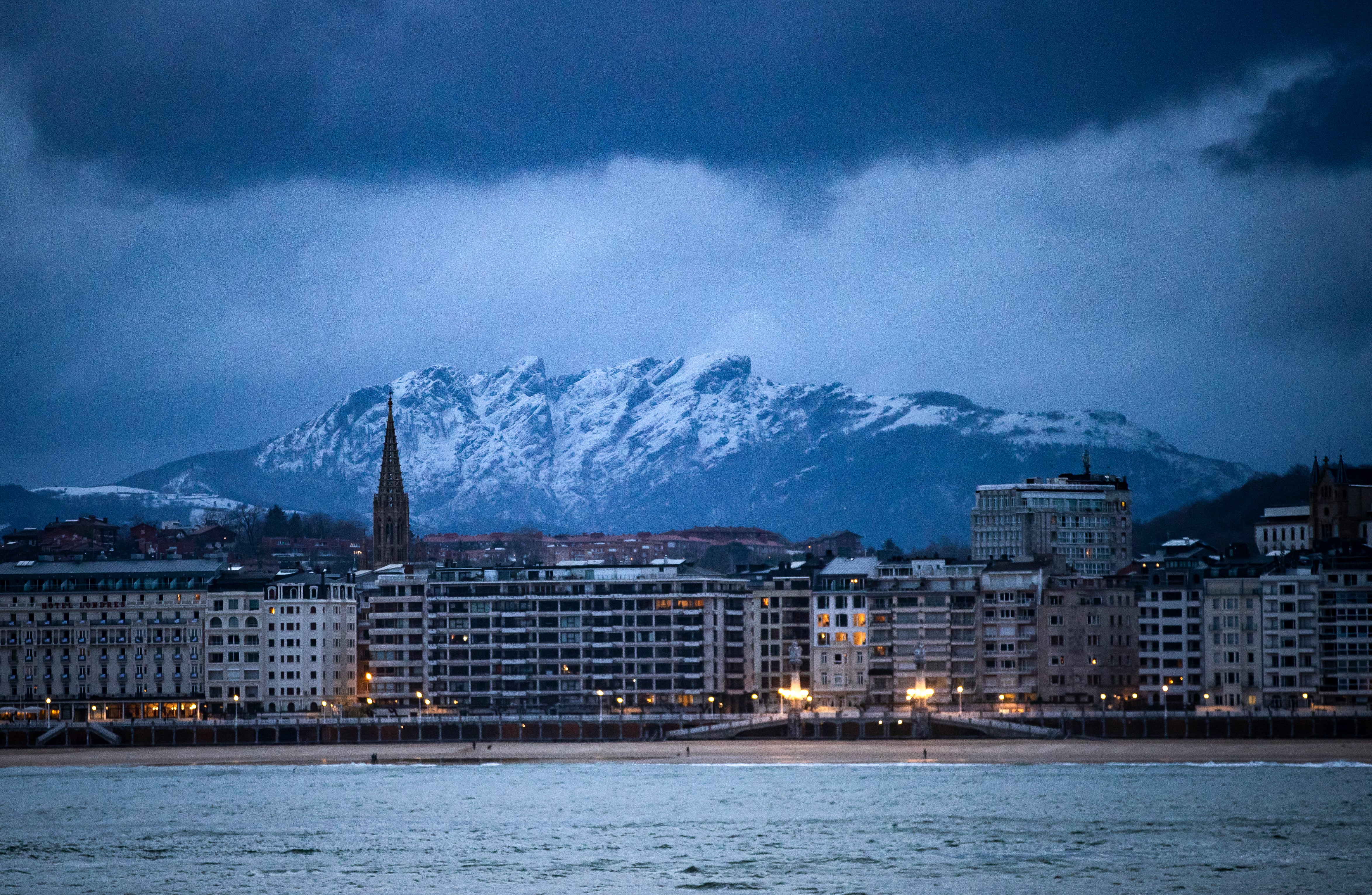 Vista de Peñas de Aia nevado desde la playa de Ondarreta de San Sebastián este miércoles.