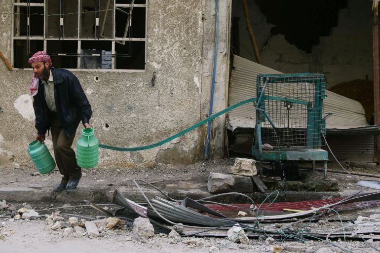  un hombre lleva agua en la asediada localidad de Douma en el Oeste de Ghouta, cerca de Damasco. 