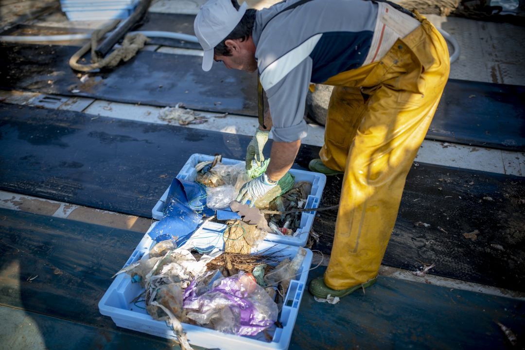 Un pescador selecciona los residuos