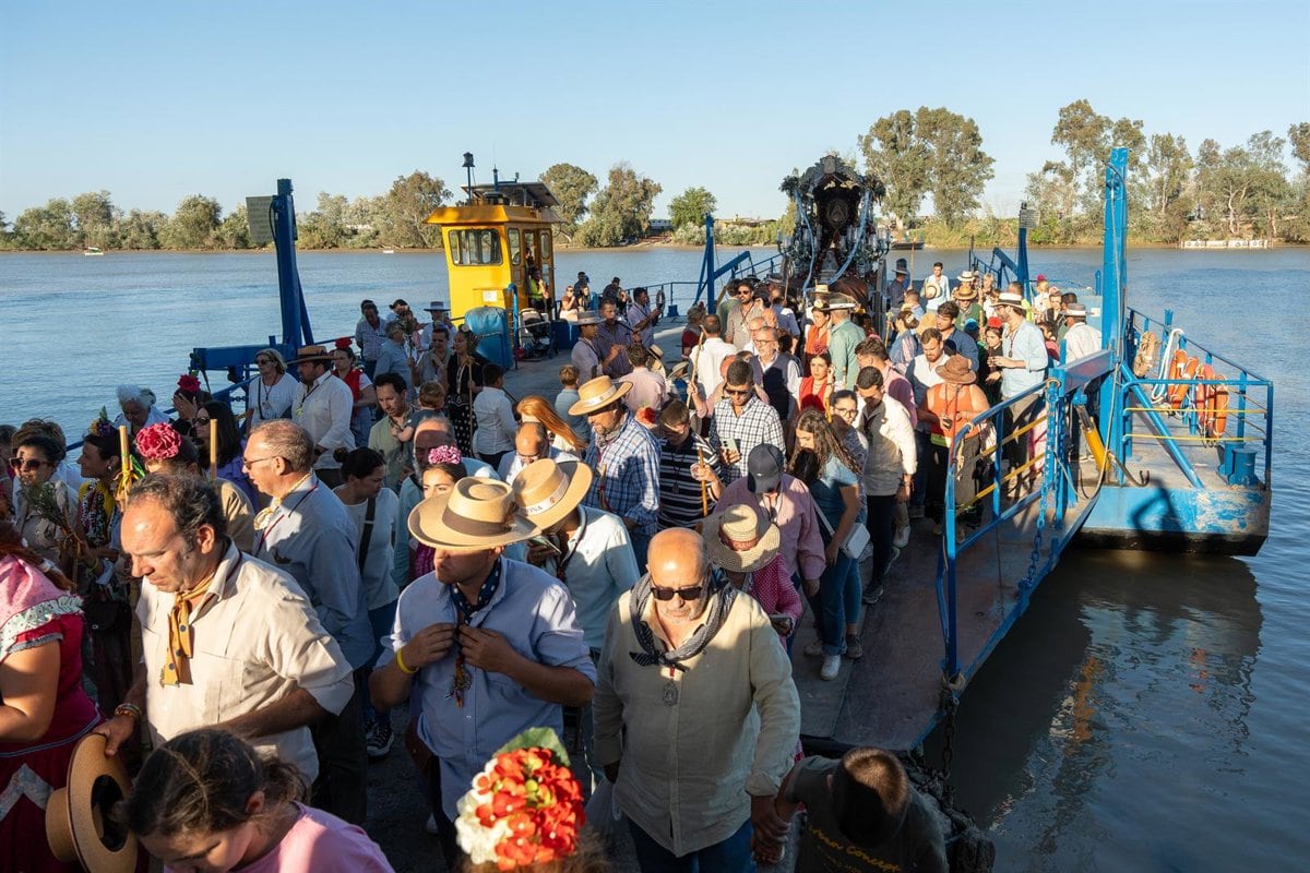 La Hermandad de Carmona desembarca de la barcaza de Coria del Río en una imagen de la Romería del año 2024
