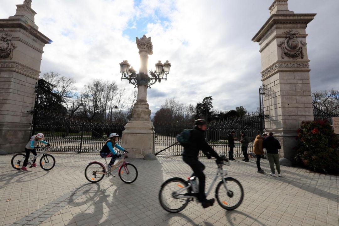 Varias personas pasan por uno de los Accesos del Parque de El Retiro que se ha reabierto al público al público este miércoles.