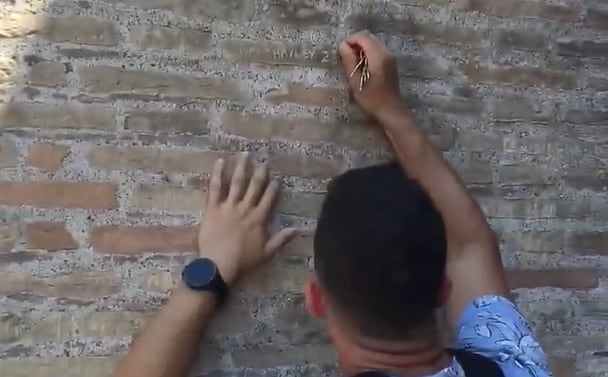 El turista grabando nombres en las paredes del Coliseo