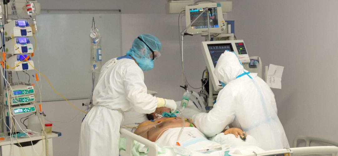 Dos sanitarios atienden a un paciente con coronavirus