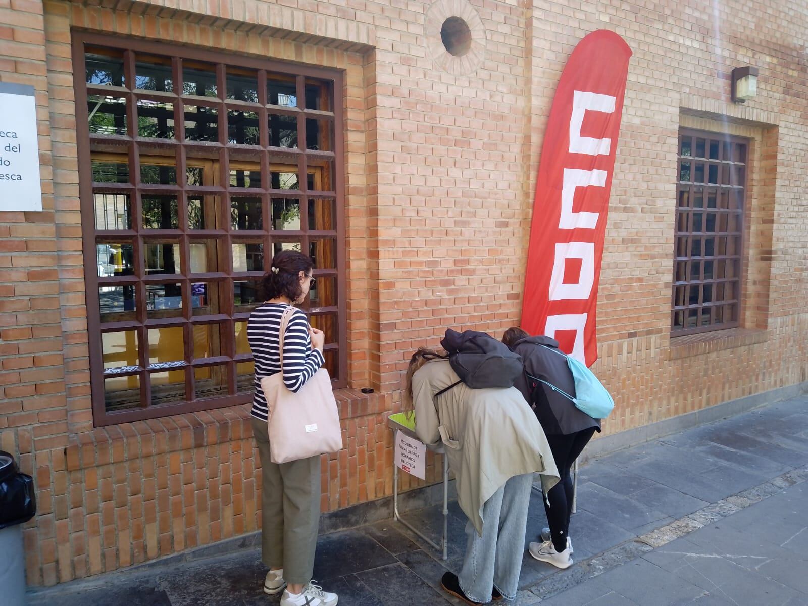 Oscenses firmando a las puertas de la Biblioteca Pública, pidiendo su reapertura por las tardes y los sábados
