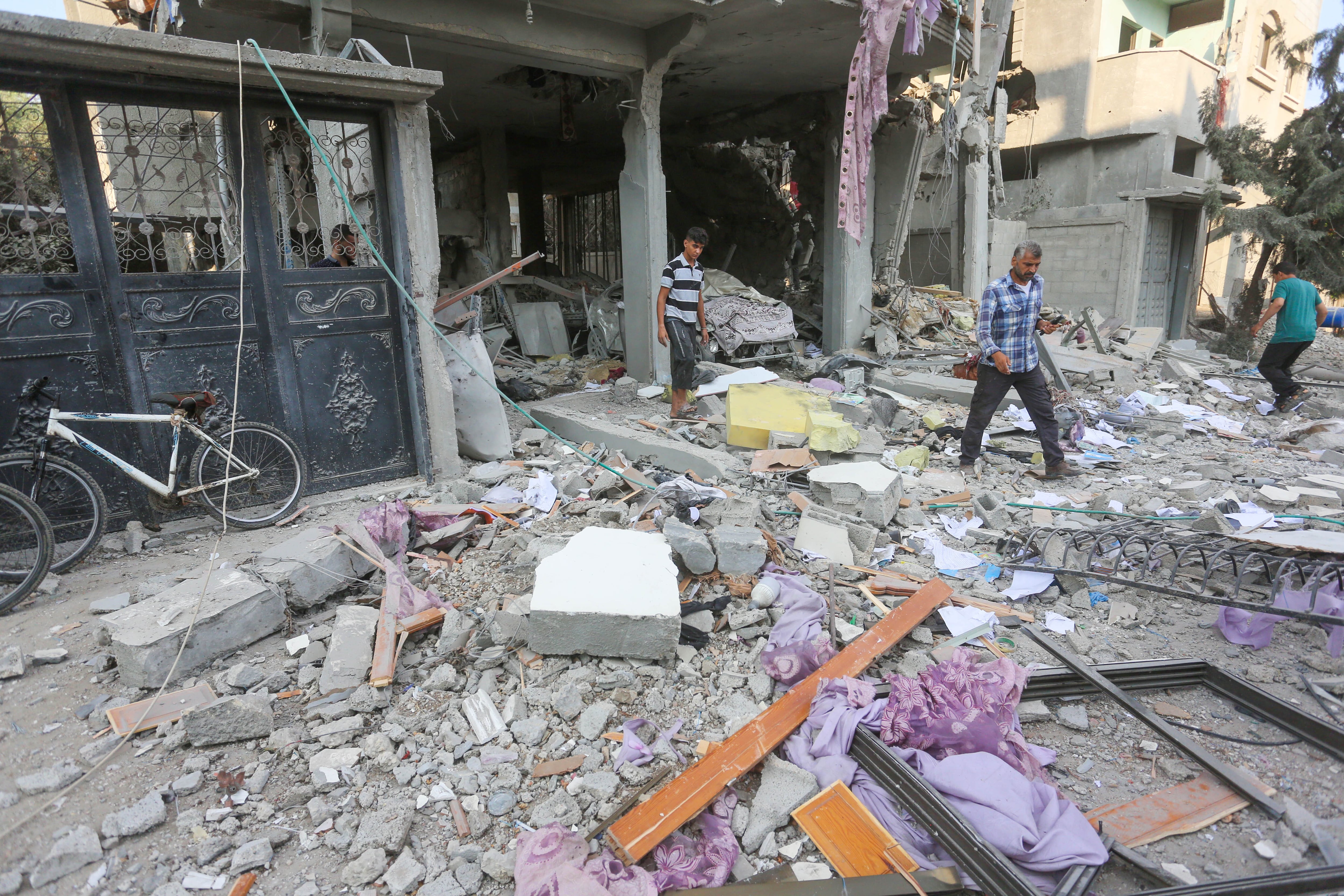 Palestinos inspeccionan una casa dañada tras un ataque israelí en el campo de refugiados de Bureij en Deir Al Balah, en Gaza