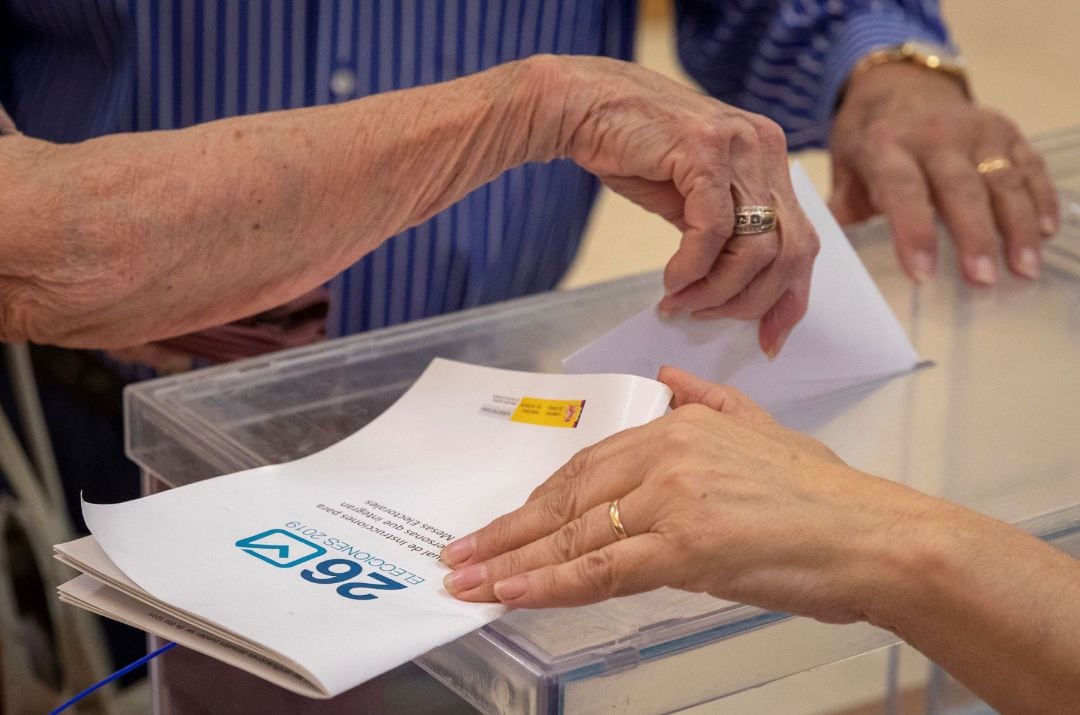 Una ciudadana deposita su voto en la urna de un colegio electoral 