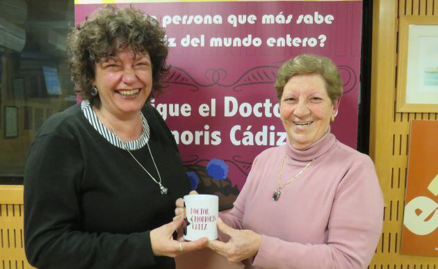 Luci Vera entrega a Mariló Maye la taza del concurso Doctorado Honoris Cádiz tras haber perdido su preliminar