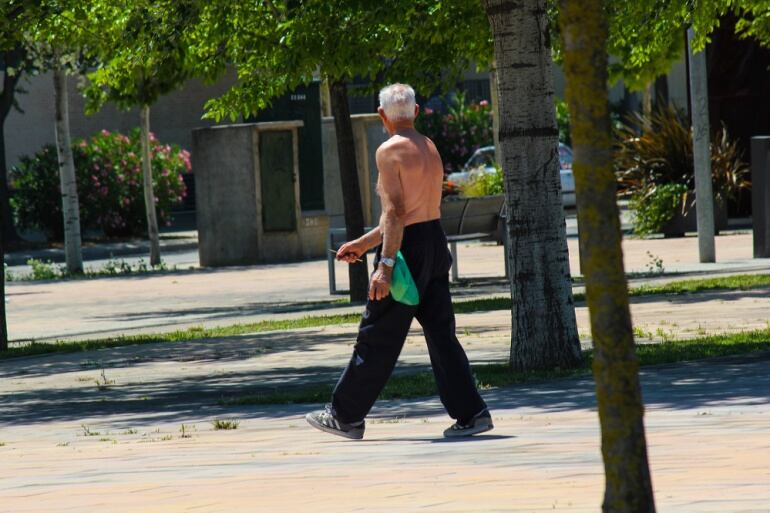 Un hombre pasea por la mañana sin camiseta debido a la alta temperatura
