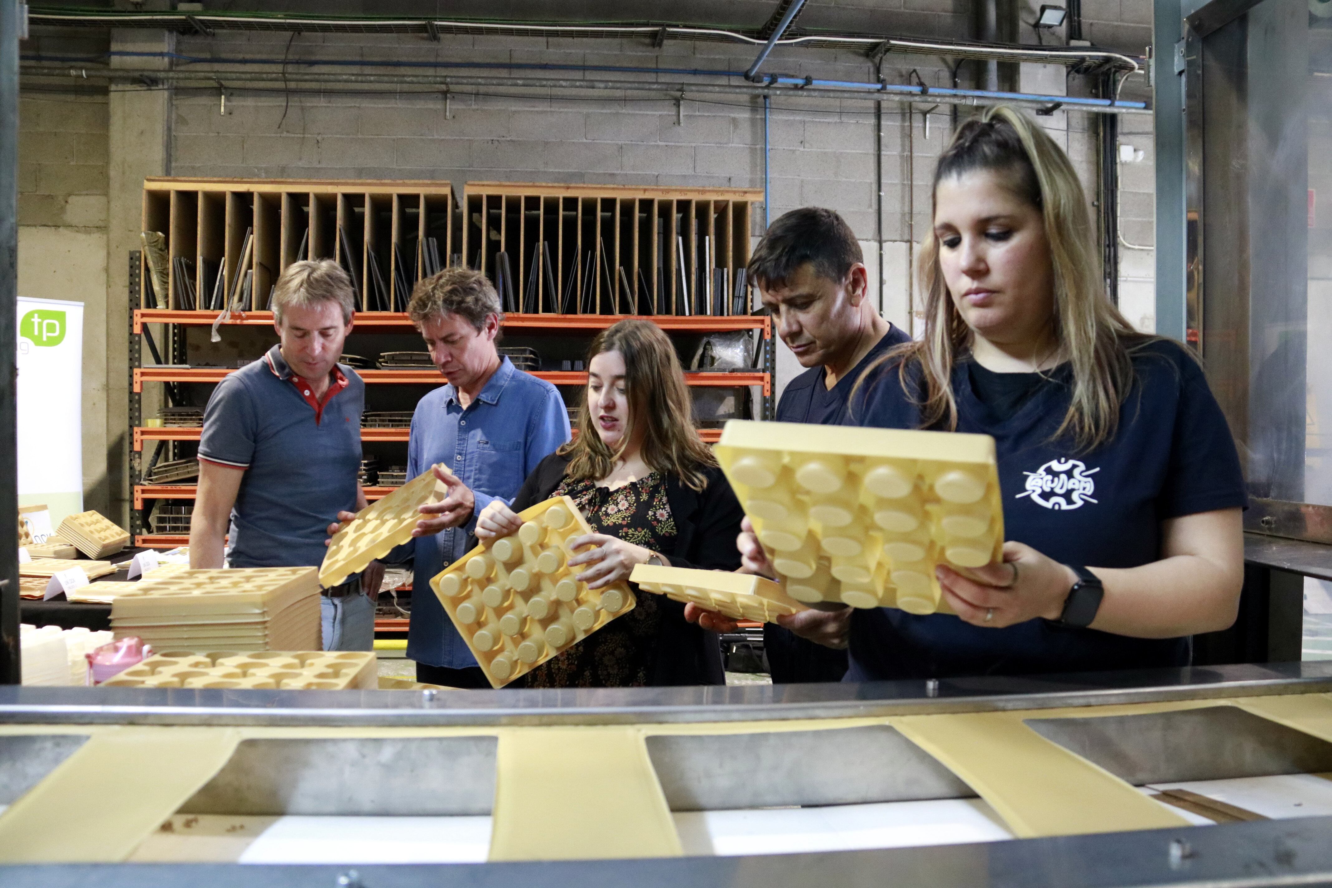 Personal d&#039;Acudam manipulant safates per a planter elaborades amb plomes d&#039;aviram al centre especial de treball d&#039;Acudam. Foto: ACN.