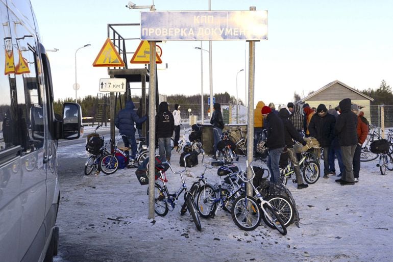 Refugiados y bicicletas en la parte rusa de la frontera con noruega esperando para entrar porque la ley rusa prohibe cruzar la frontera a pie.