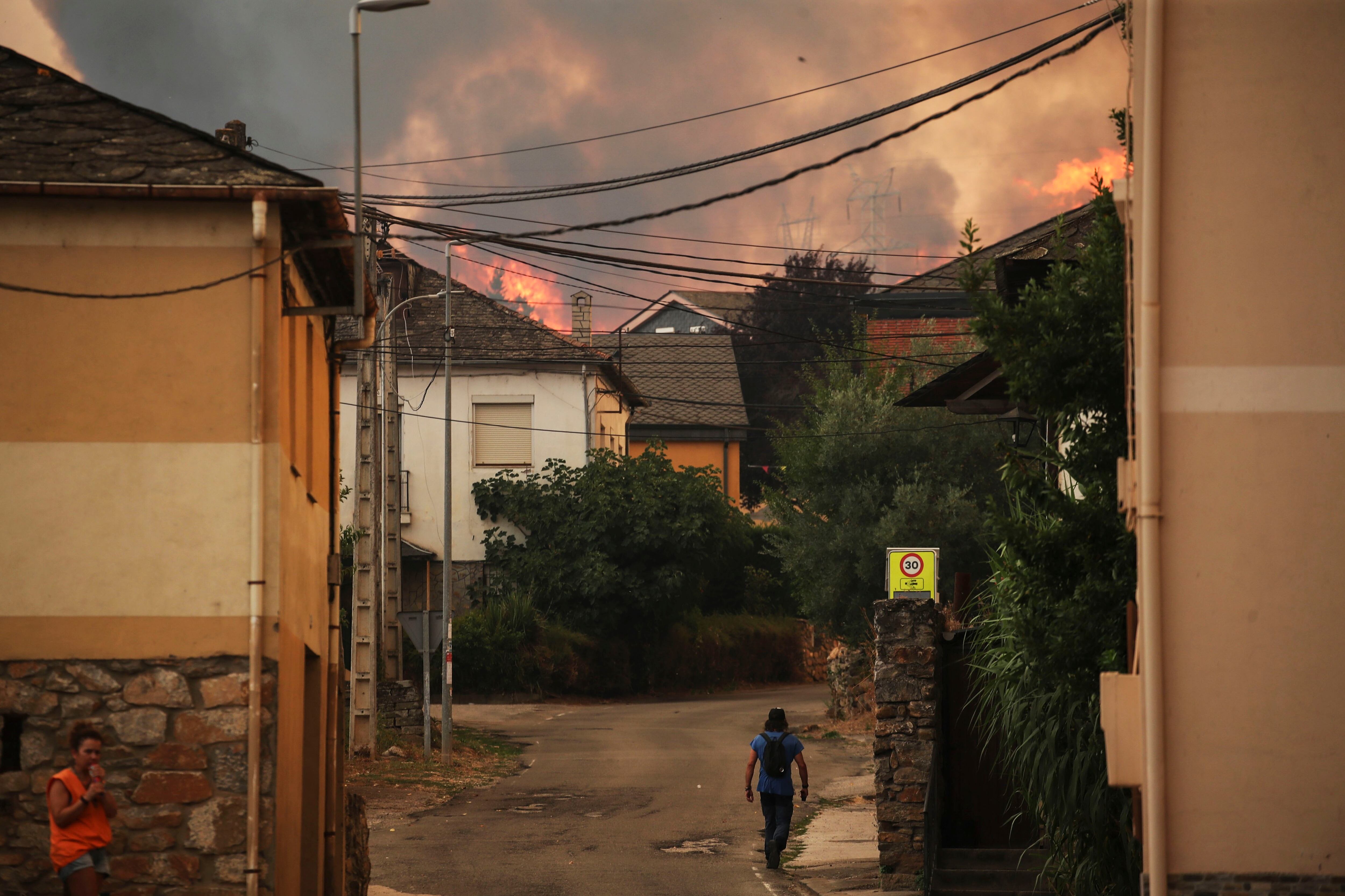 LAS MÉDULAS (LEÓN ), 10/08/2025.- Un hombre camina en las proximidades del incendio forestal que afecta al Parque de Las Médulas y que provocó desalojos en los municipios de Médulas y Orellán. Un día más y en medio de un calor sofocante, las labores de extinción continúan en varios incendios de la Península. EFE/ Ana F Barredo