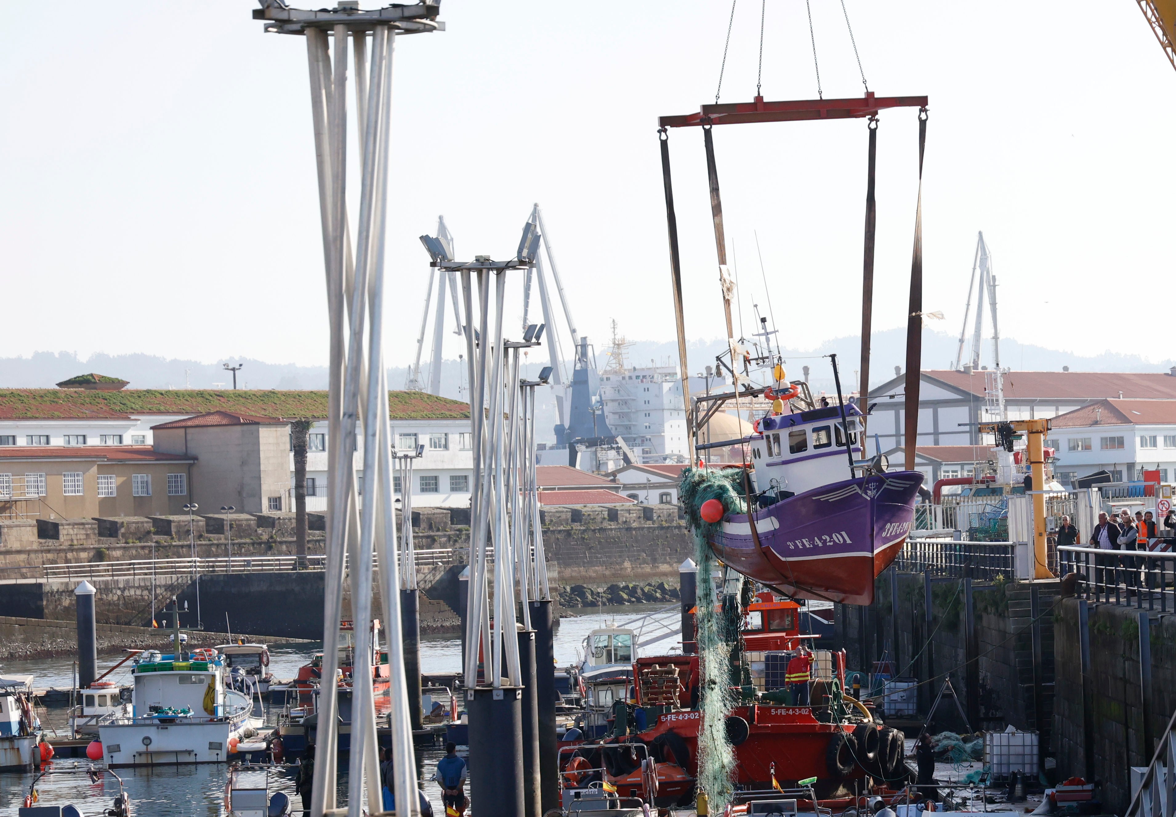 Reflotan un barco pesquero en el puerto de Ferrol que se había hundido de madrugada y que estaba completamente inundado (foto: Kiko Delgado / EFE)