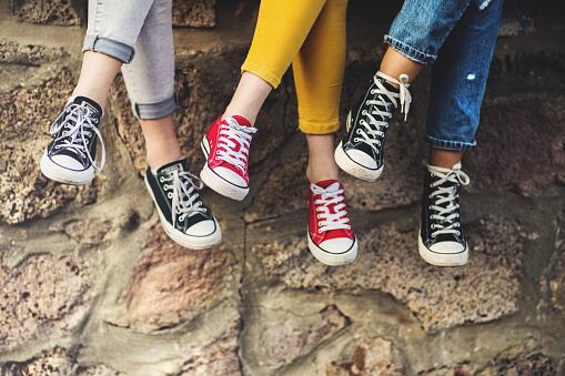 Adolescentes sentadas en un muro de piedra
