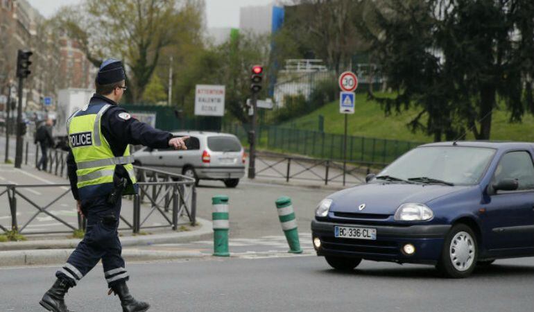 Un policía da el alto a un vehículo en París (Francia).