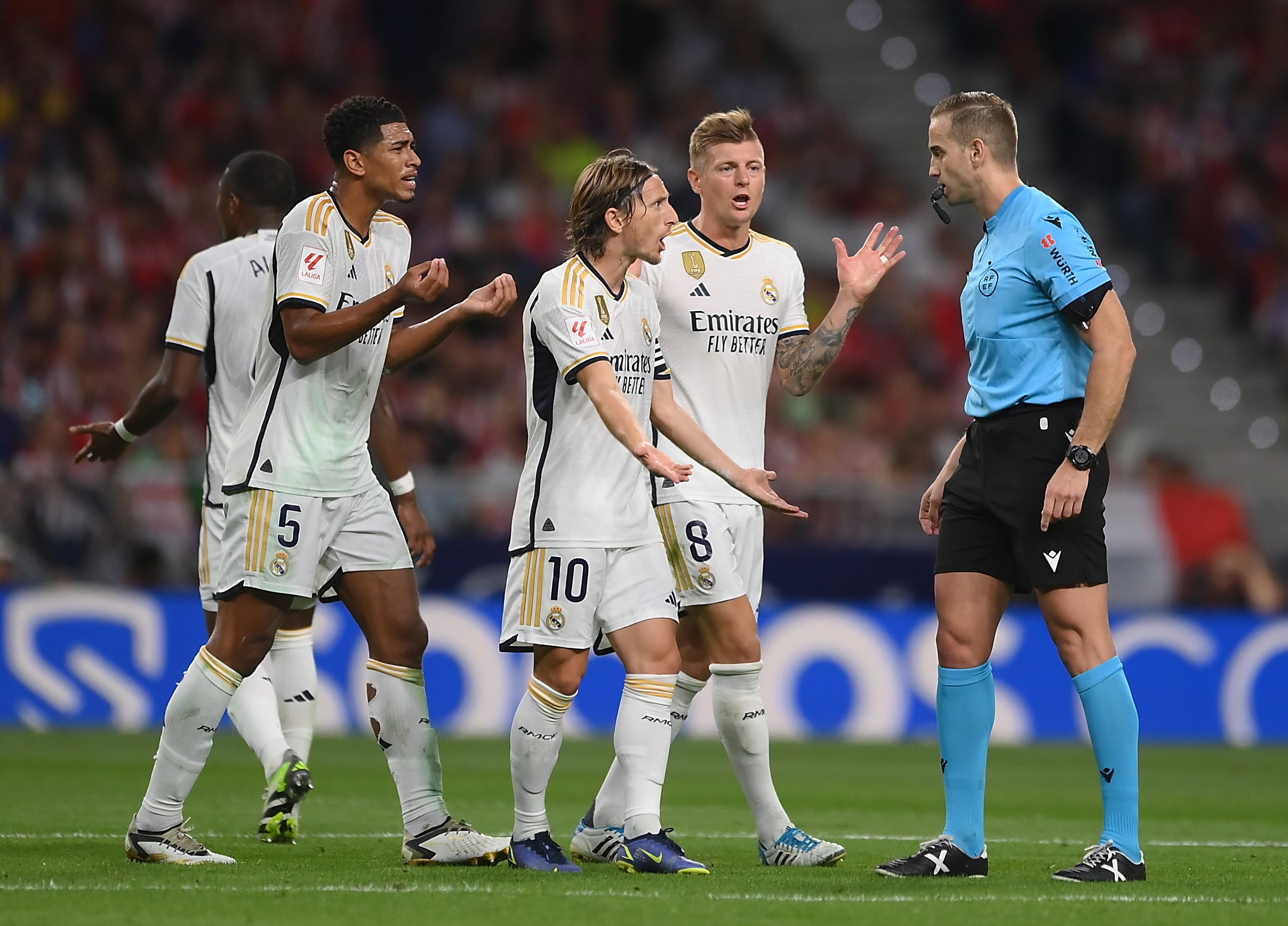 Los jugadores del Real Madrid protestan a Javier Alberola durante el derbi madrileño