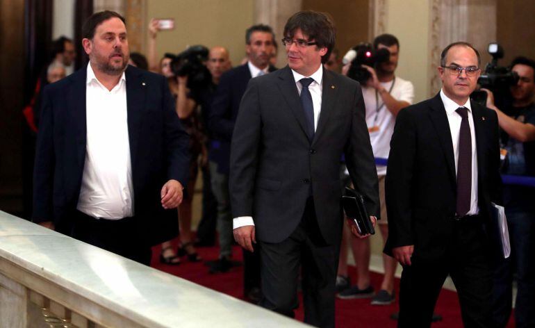 El presidente de la Generalitat, Carles Puigdemont (c), junto al vicepresidente y conseller de Economía, Oriol Junqueras (i), y el conseller de la Presidencia, Jordi Turull 