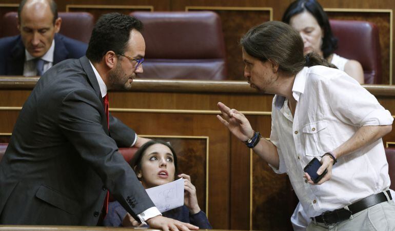 El secretario general de Podemos, Pablo Iglesias, conversa con el diputado socialista Antonio Hernando, durante la sesión constitutiva de las Cortes Generales de la XII Legislatura.