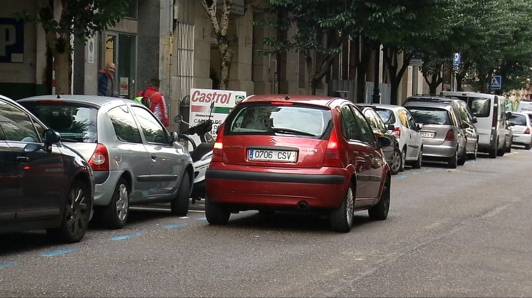 Vehículo en doble fila busca aparcar en zona azul en Vigo.