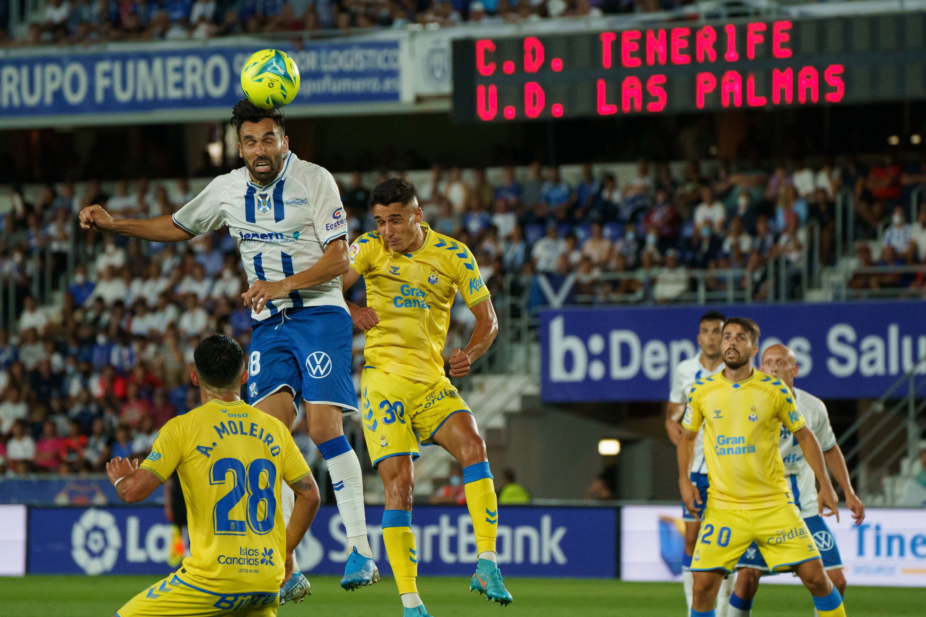 El delantero del CD Tenerife Enric Gallego (2-i) cabecea un balón ante Sergi Cardona (3-i), de la UD Las Palmas, durante el partido de la primera eliminatoria del playoff de ascenso a Primera División que se disputa este miércoles en el estadio Heliodoro Rodríguez López. EFE/Ramón de la Rocha