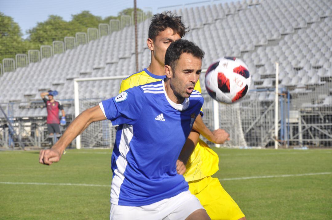 Pedro Carrión tratando de controlar un balón con la marca de un defensa 