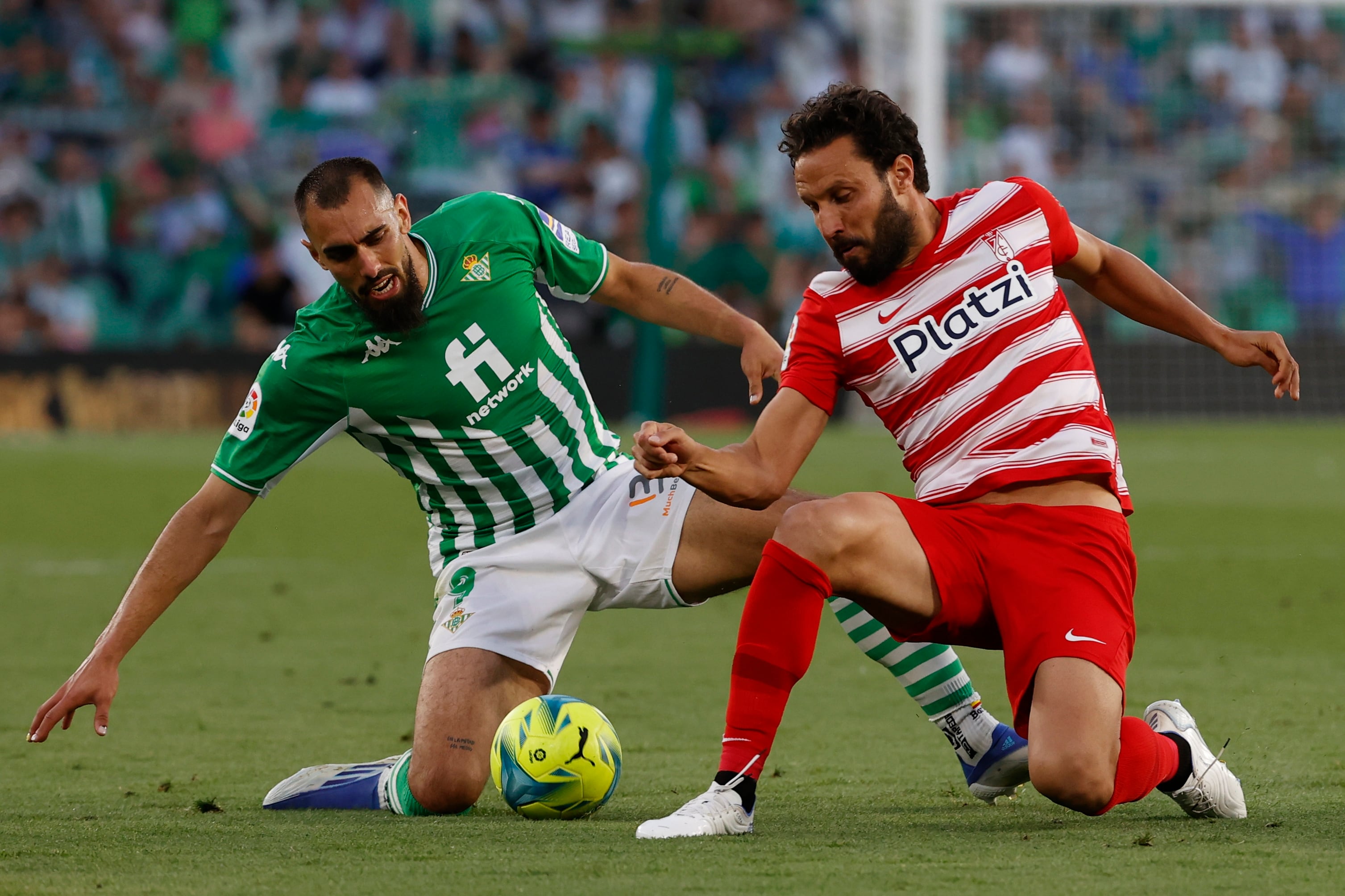 SEVILLA, 15/05/2022.- El delantero del Betis, Borja Iglesias (i), disputa el balón ante el defensa del Granada, German, durante el encuentro correspondiente a la jornada 37 de primera división que disputan hoy domingo en el estadio Benito Villamarín de Sevilla. EFE/Julio Muñoz
