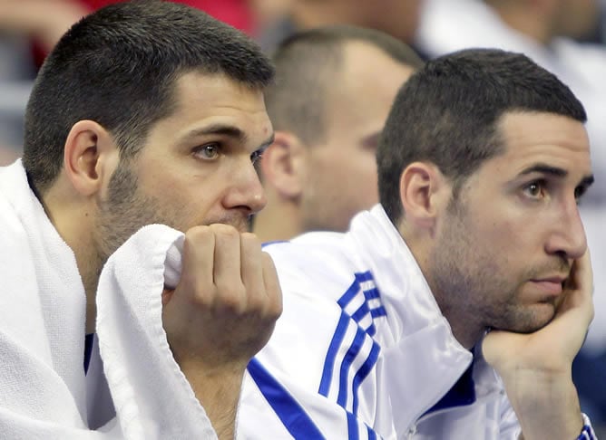 Los jugadores del Real Madrid Felipe Reyes (i) y Sergi Vidal (d), tras perder por 62-80 ante el Montepaschi Siena