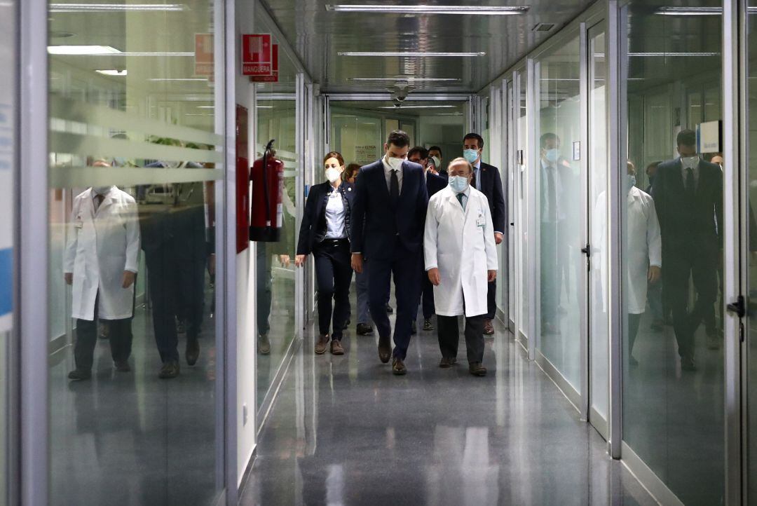 El presidente del Gobierno, Pedro Sánchez (i), pasea por los pasillos de la Unidad Central de Investigación Clínica y Ensayos Clínicos del Hospital La Paz, en Madrid