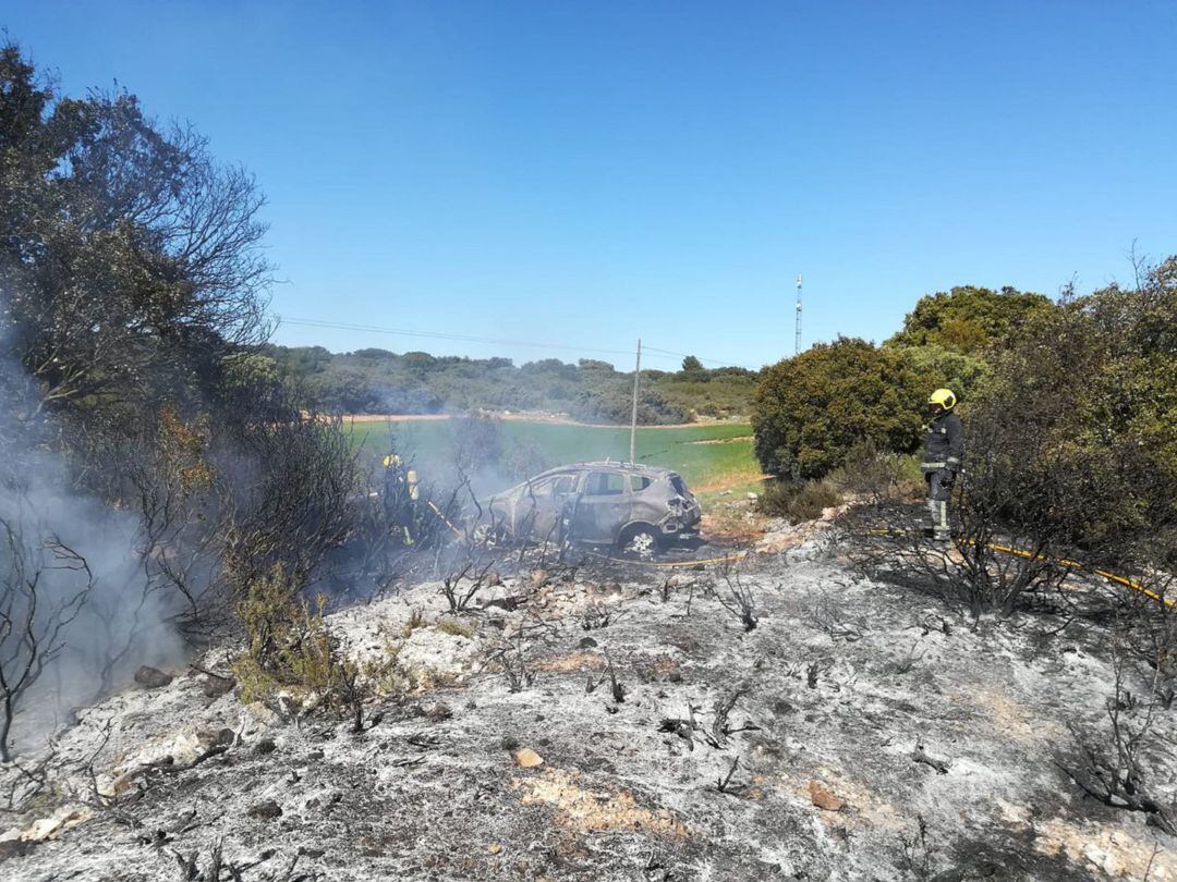 El coche calcinado provocó un pequeño incendio en el matorral cercano.