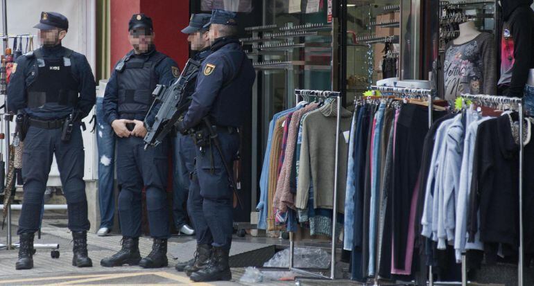 Varios miembros de la Policía española en la puerta de un comercio.